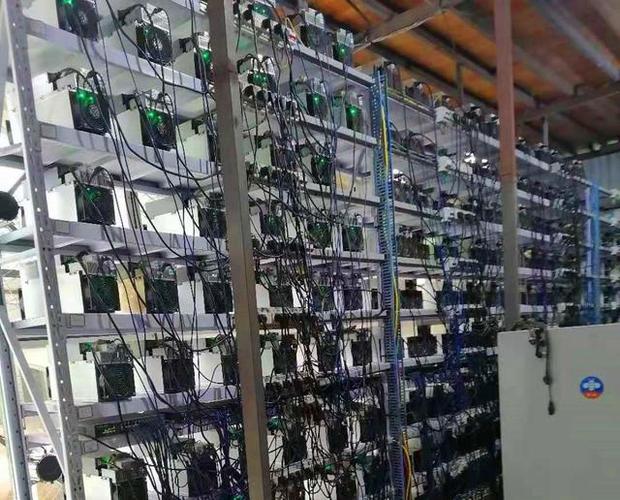 Technician maintaining mining rigs at a hosting facility